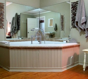 Wildrose tub that is a 70 gallon soaking tub with mirrors on the wall around it. 